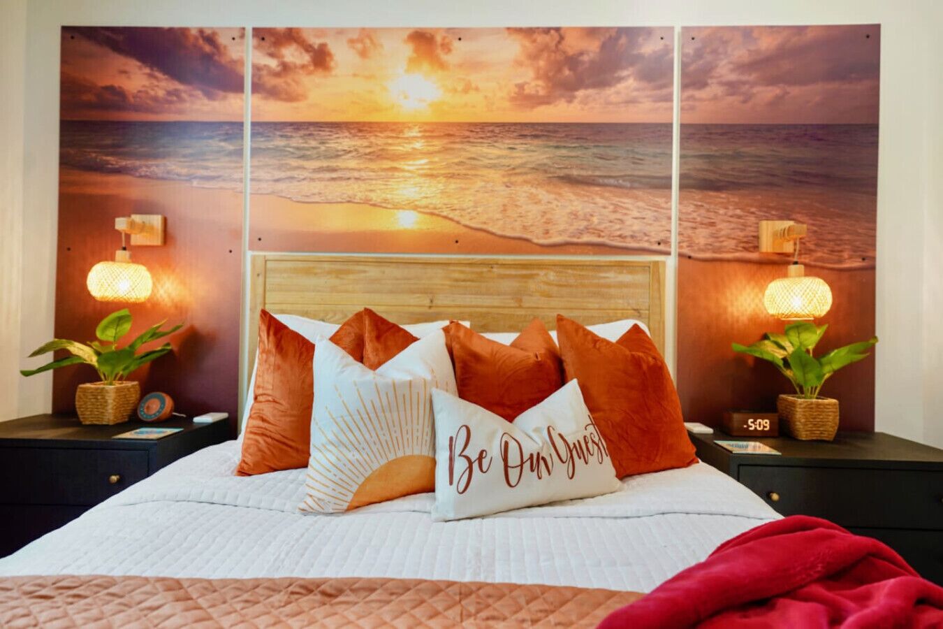 Un lit avec vue sur le coucher de soleil, de nombreux oreillers et des lampes de chevet.