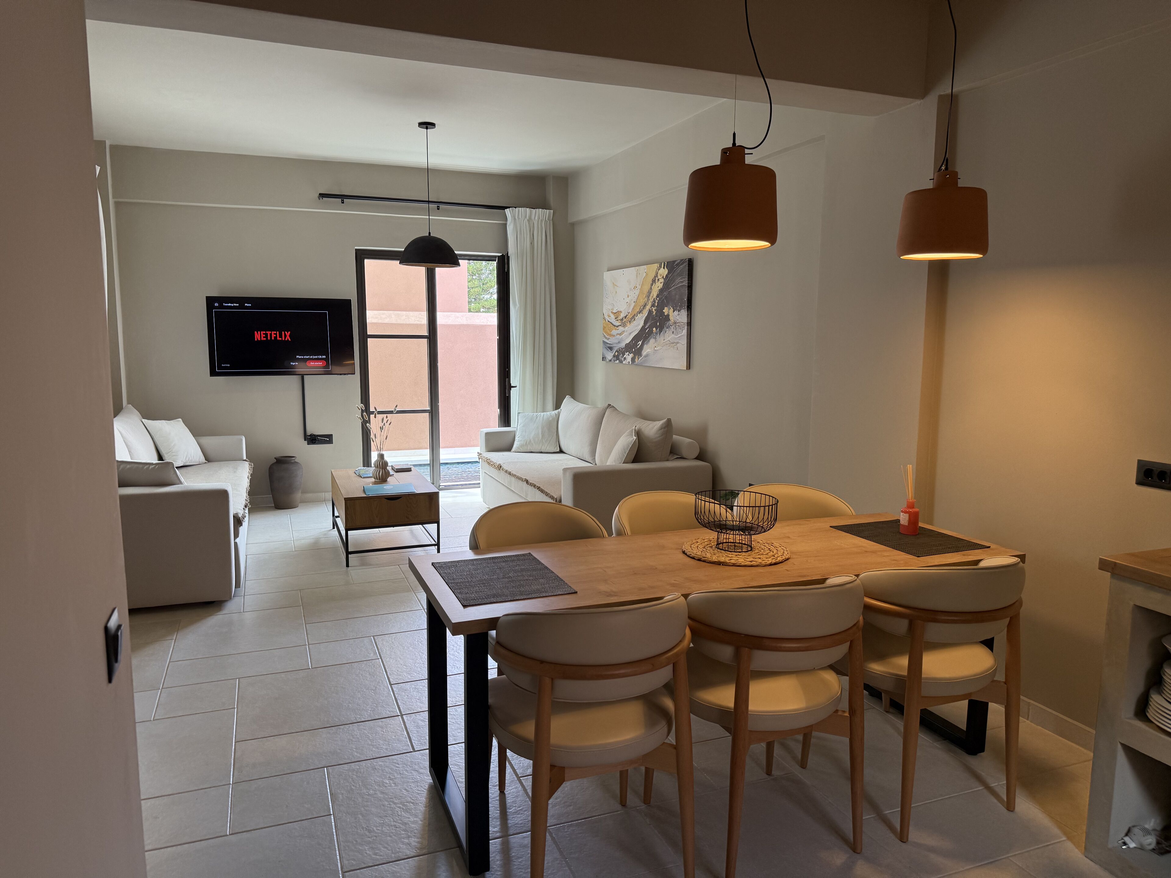 A modern living room with a sofa, a coffee table, and a TV mounted on the wall.