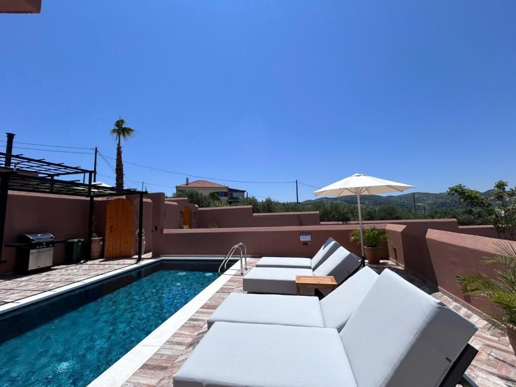 A rooftop pool area with lounge chairs and a view of the surrounding landscape.