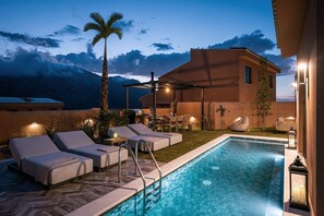 A poolside area with lounge chairs, a barbecue, and a pergola. - ARCĀSA Villas Collection by Omilos Hotels (Archanes-Asterousia)