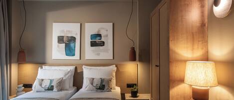 Ein Hotelzimmer mit zwei Betten, einem Nachttisch mit Lampe und einem Bild an der Wand.