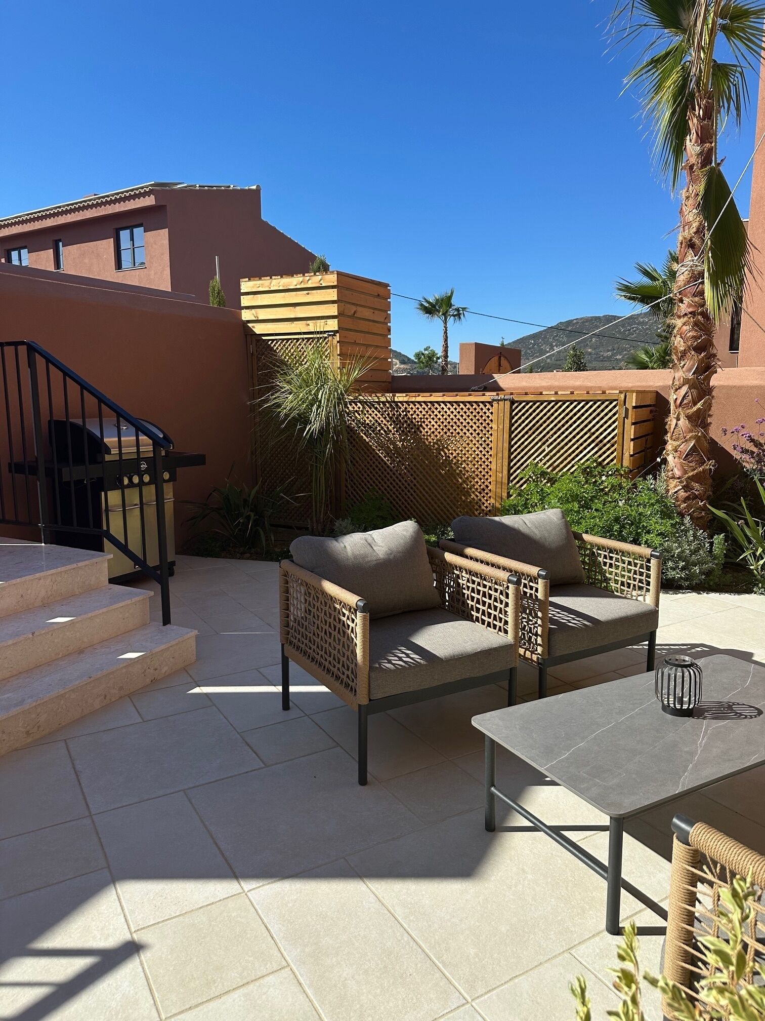 A patio with outdoor furniture, a staircase, and a view of the surrounding area.