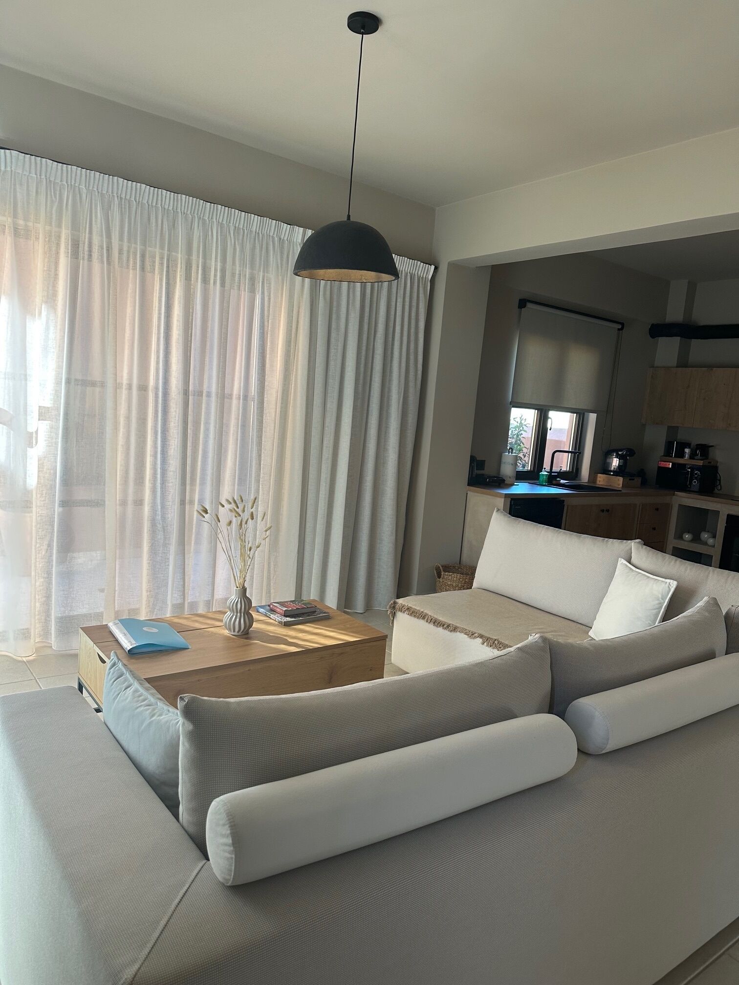 Una sala de estar moderna con sofá, mesa de centro e iluminación colgante.