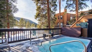 A hot tub area with a wooden deck, surrounded by trees and a view of mountains. - 3 Bedroom Condo at Key Condo in Keystone (Keystone)