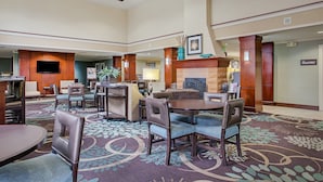 Un hall d’entrée spacieux avec une cheminée, des sièges confortables et un panneau indiquant l’emplacement du garde-manger.