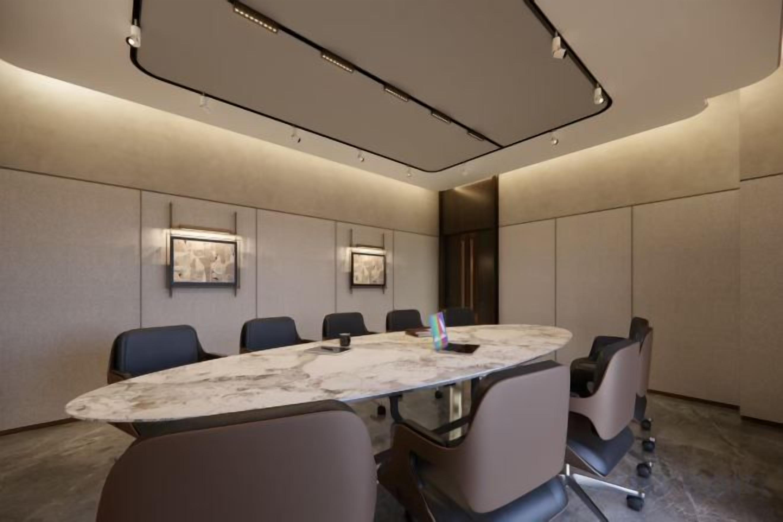 Una sala de conferencias con una mesa de mármol, seis sillas y un diseño moderno en el techo.