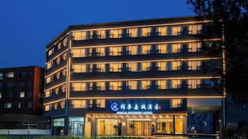 Un hotel de varios pisos con una entrada llamativa y señalización.