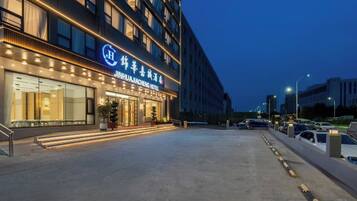 A hotel entrance with a modern facade, large windows, and a well-lit entrance area.