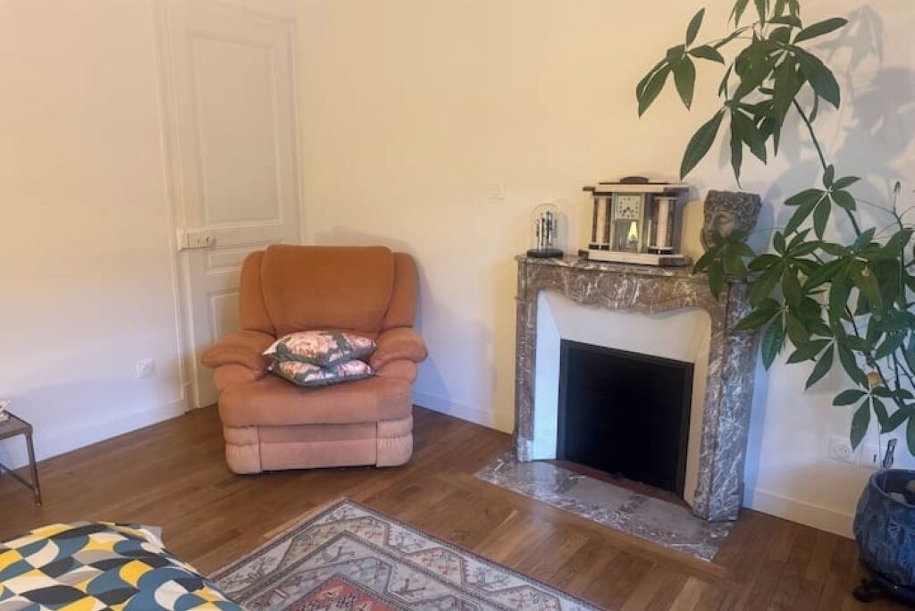 Un salon avec une cheminée, un canapé et un tapis à motifs.