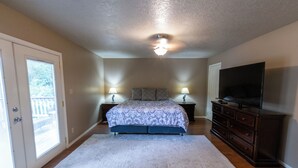 A bedroom with a bed, dresser, TV, and two lamps. - Spacious home in the heart of Emmett (Emmett)