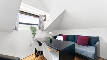 Une chambre de style loft moderne, comprenant un coin repas, un canapé et une petite table.