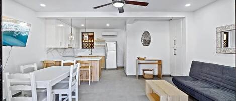 Un espace de vie moderne comprenant un coin repas, une cuisine et un coin salon.