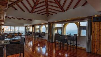 A spacious dining area with high ceilings and large windows offering ocean views.