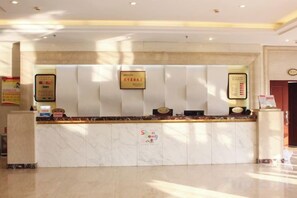 A hotel reception desk with a marble counter, framed certificates, and a reception area. - Weihai Electronic Hotel (Weihai)