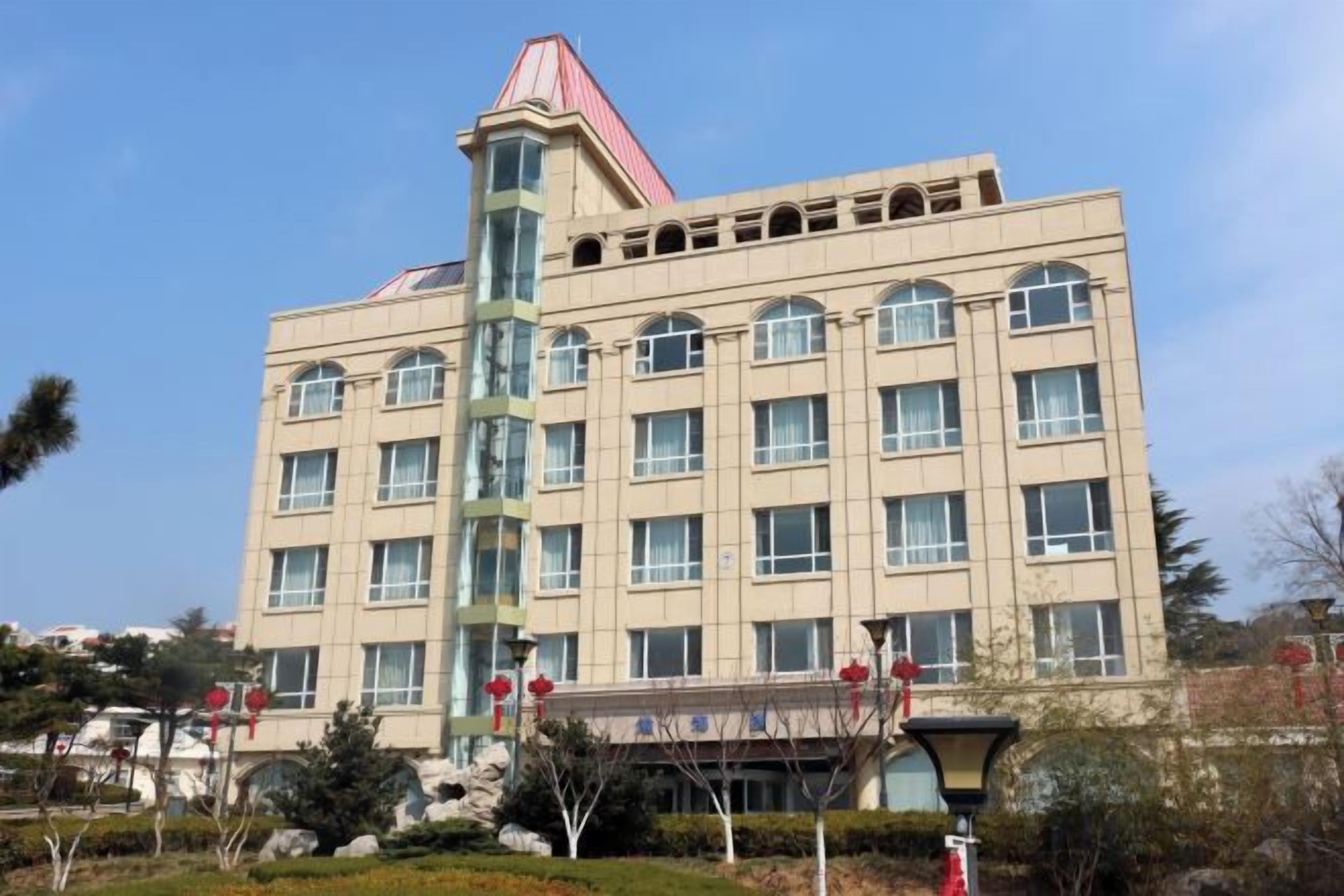 Un edificio de varios pisos con un techo rojo característico y una torre central de cristal.