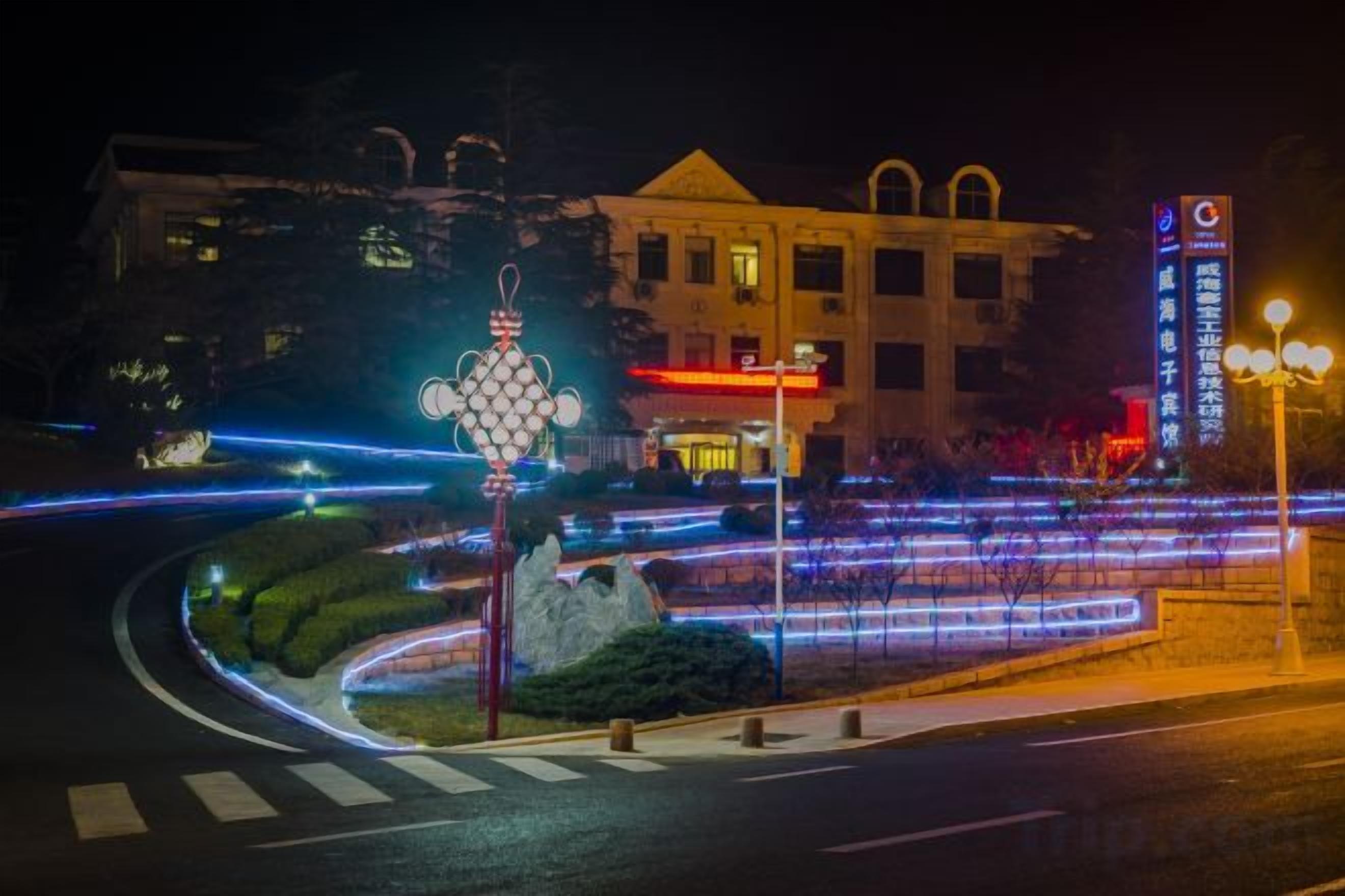 Un edificio con un ingresso evidente e una strada ben illuminata di fronte.