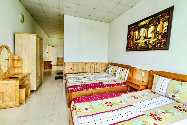 A room with a wooden bed, a wooden wardrobe, and a mirror.