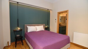A bedroom with a bed, a chair, a nightstand, and a mirror. - Athens top floor stylish 2 min walk to metro Panepistimio (Athina)