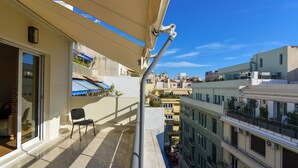 A balcony with a chair, a glass door, and a view of neighboring buildings. - Athens top floor stylish 2 min walk to metro Panepistimio (Athina)