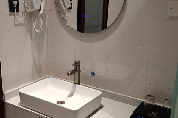 A modern bathroom with a white sink, a mirror, and a towel rack. - Jingtu Hotel (Beihai Hunan Road) (Beihai)