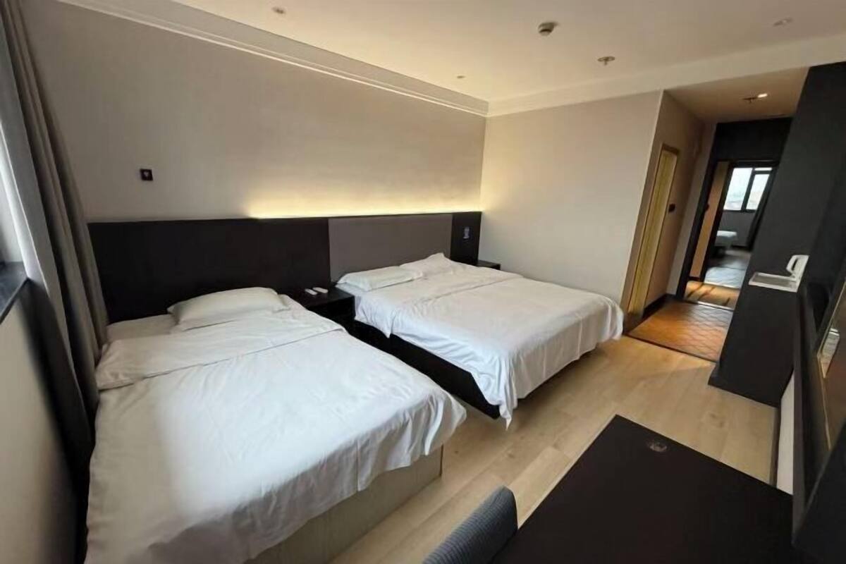 Ein Hotelzimmer mit zwei Betten, einem Schreibtisch und einem Stuhl.