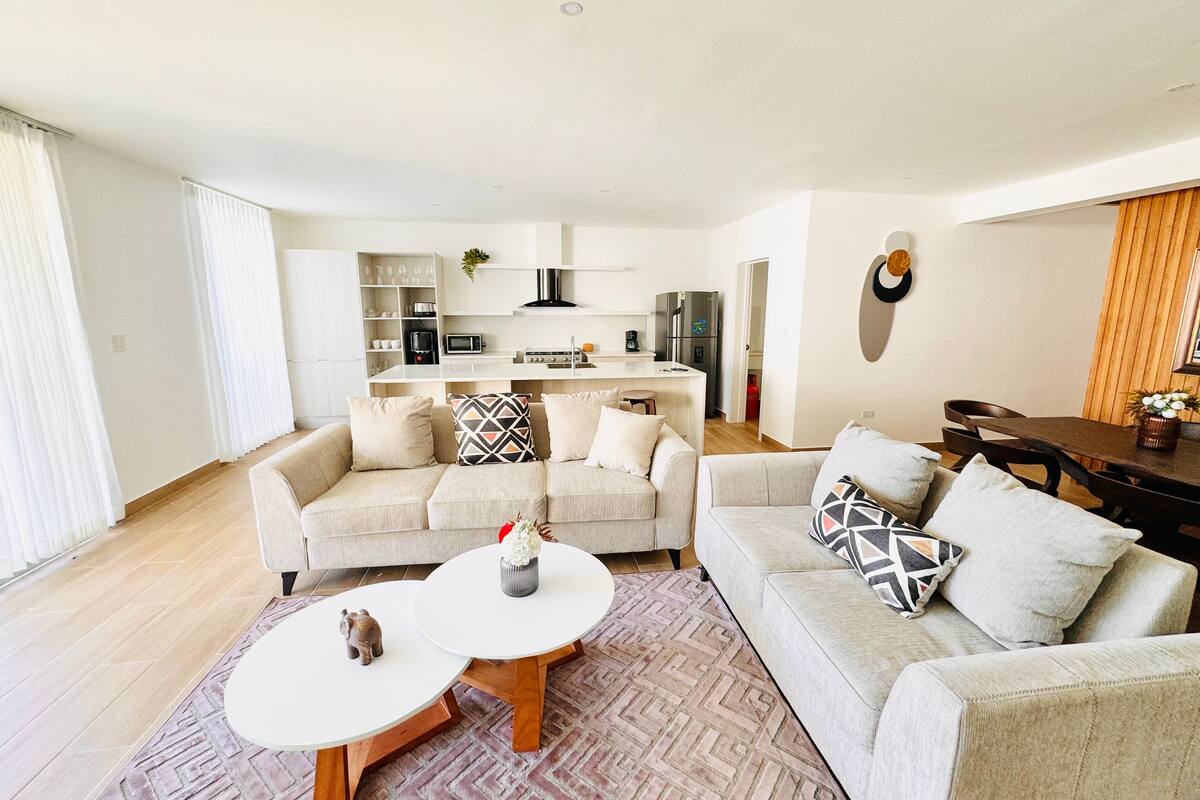Ein modernes Wohnzimmer mit zwei Sofas, einem Couchtisch und einem Esstisch.