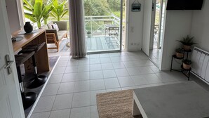 Et moderne køkken med spiseplads, store vinduer og en skydedør til en balkon.