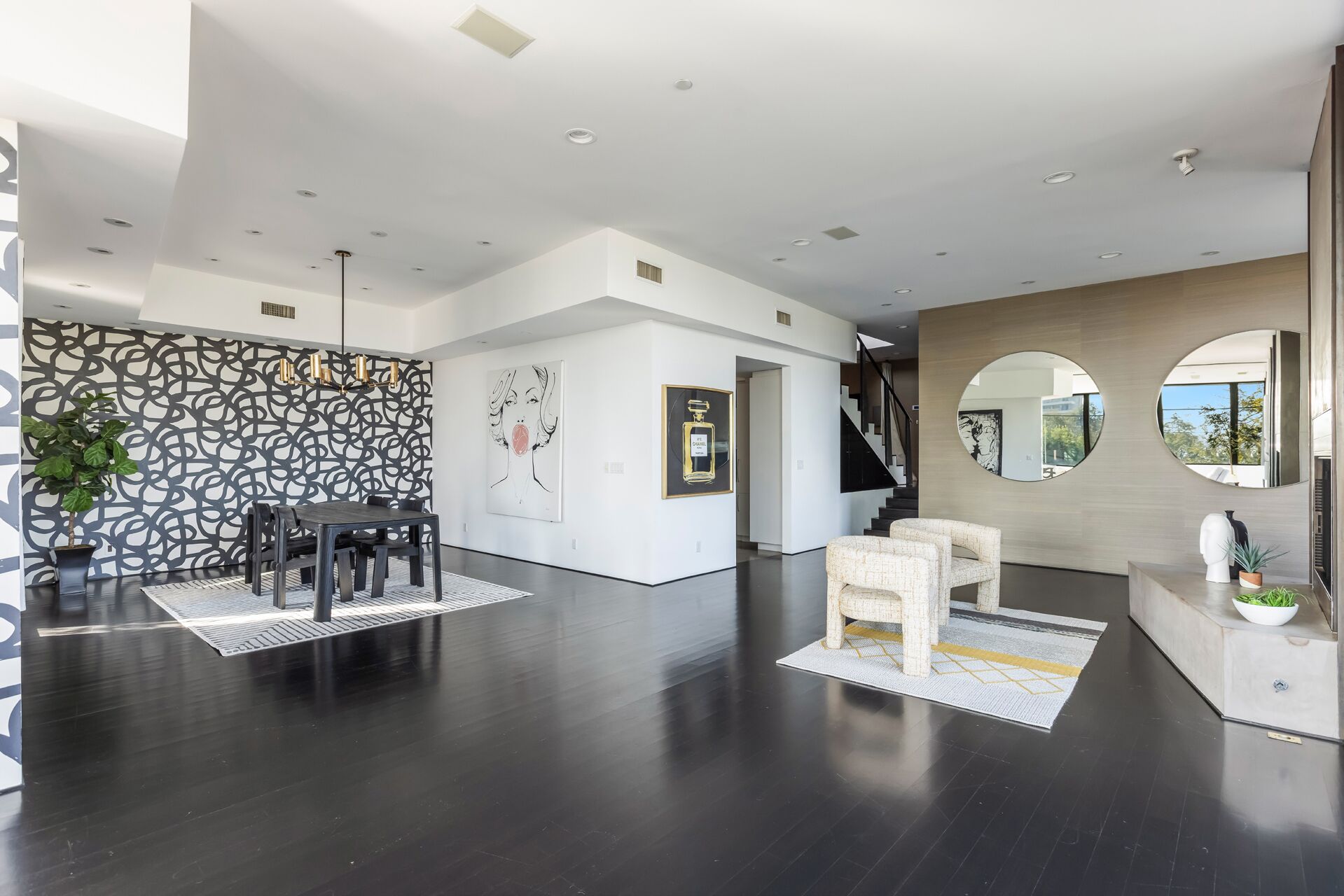 A spacious, modern interior with a dining area, a staircase, and a living space.