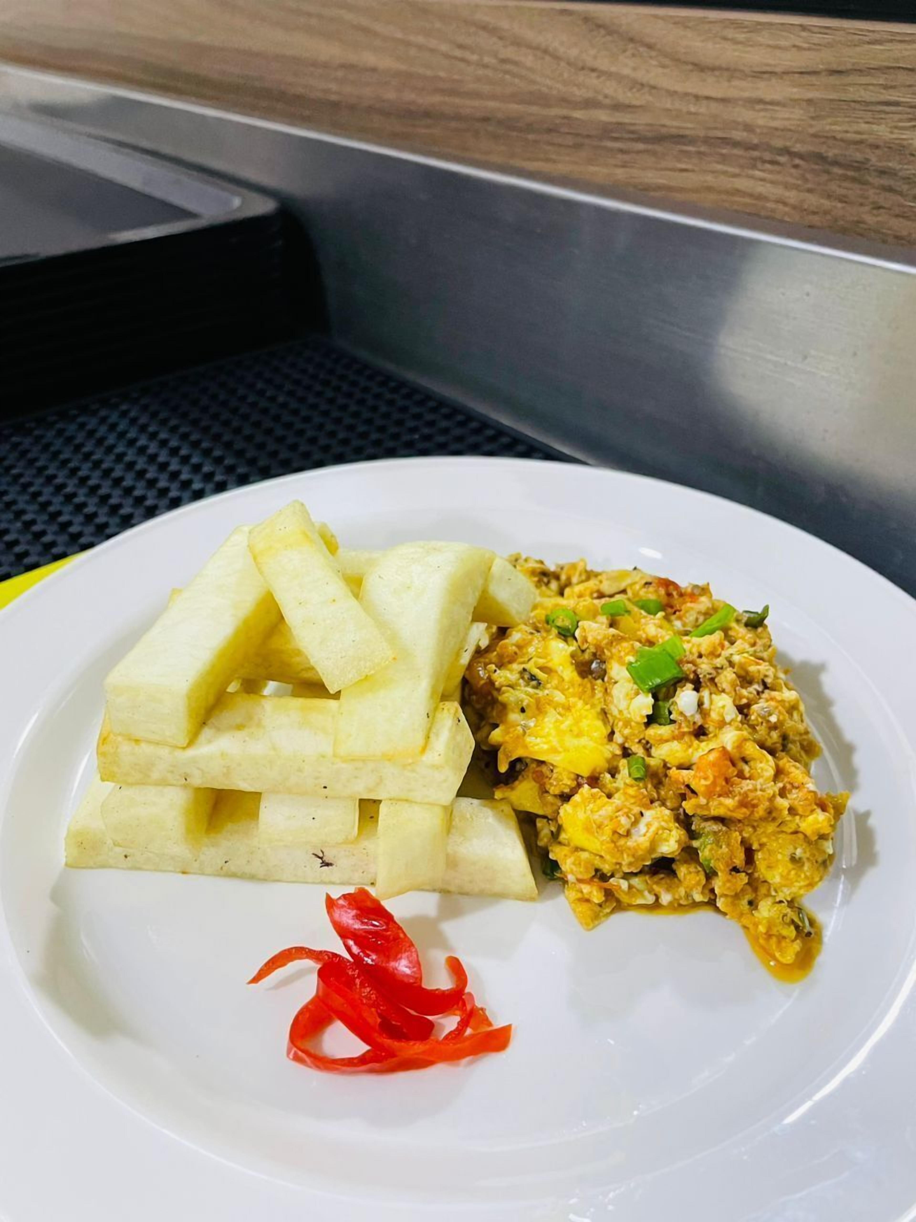Un plato con arroz frito y papas fritas sobre un plato blanco.