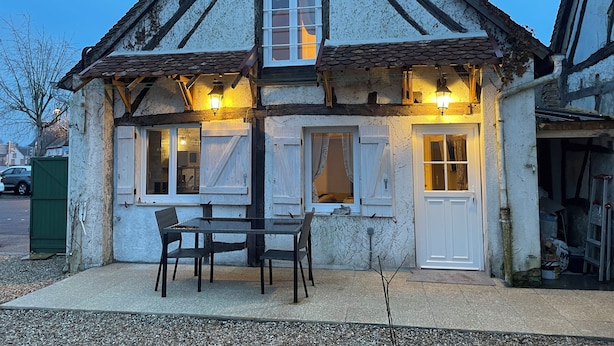 A traditional half-timbered house with a dining area outside, featuring a table and chairs. - Le logis des Glycines (6 adults 2 children) in the heart of the village of Nançay en Sologne (Nançay)