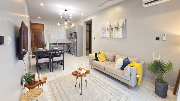 A modern living room with a sofa, coffee table, and a dining area with a table and chairs. - Casa JV Poolhouse 2-Bed Apartment, Dar es Salaam (Dar es Salaam)