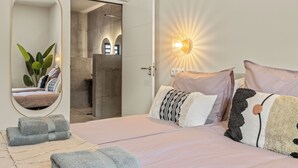 Une chambre à coucher avec un grand lit, un miroir et une table de chevet.