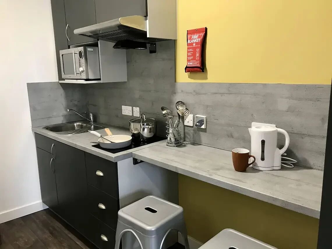 Eine kleine Küche mit Mikrowelle, Wasserkocher und Kaffeemaschine.