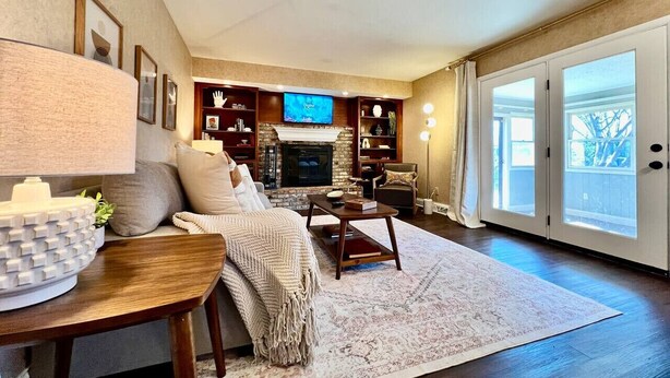 A living room with a fireplace, a television, and a large window. - All the Vibes Poolside in Trenton! (Trenton)