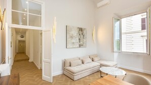 A modern living room with a sofa, a round coffee table, and a large window.
