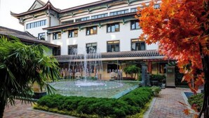 Un edificio tradicional con un patio, una fuente y un jardín bien cuidado.