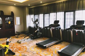 A hotel room with a treadmill, stationary bike, and elliptical machine. - Jianhua International Hotel (Chuxiong City)