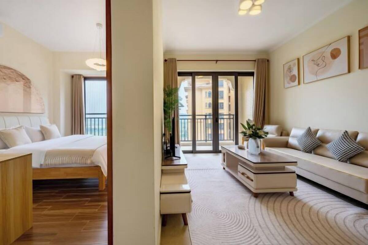 Une chambre d’hôtel avec un lit, un canapé, une table basse et une vue sur l’extérieur.
