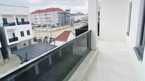A modern apartment with a balcony overlooking a residential area. - Merryway Apartment (Abuja)