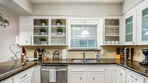 A kitchen with white cabinets, a granite countertop, a stainless steel sink, and a window with blinds. - Spacious 4BR/2.5BA Houston Home, Pool, WiFi & AC Included (Houston)