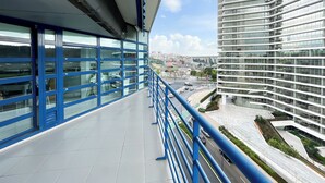 A modern building with a glass facade and a blue railing overlooking a cityscape. - Prestige Lisbon Entire 3 Bedroom Luxury Family Friendly Apartment (Lisboa)