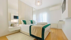 A modern bedroom with a bed, bedside table, lamp, and a large window with curtains. - Prestige Lisbon Entire 3 Bedroom Luxury Family Friendly Apartment (Lisboa)