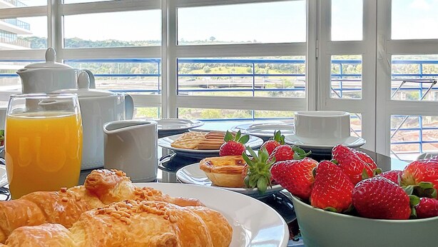 A breakfast table with croissants, strawberries, a glass of orange juice, and a pitcher of coffee. - Prestige Lisbon Entire 3 Bedroom Luxury Family Friendly Apartment (Lisboa)