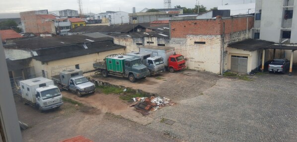 A parking area with several trucks and a small building. - Hotel Fenix (Aracaju)