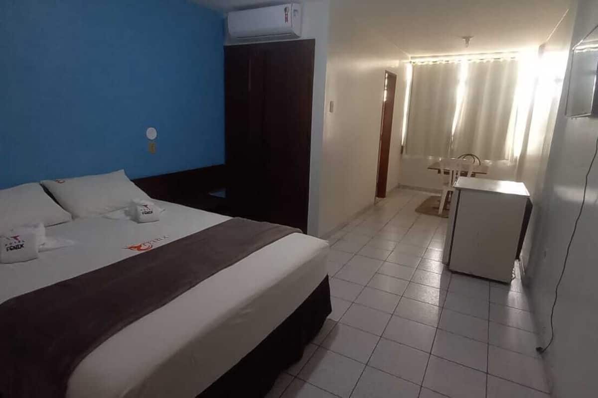 Une chambre d’hôtel équipée d’un lit, d’un bureau, d’une chaise et d’une petite kitchenette.