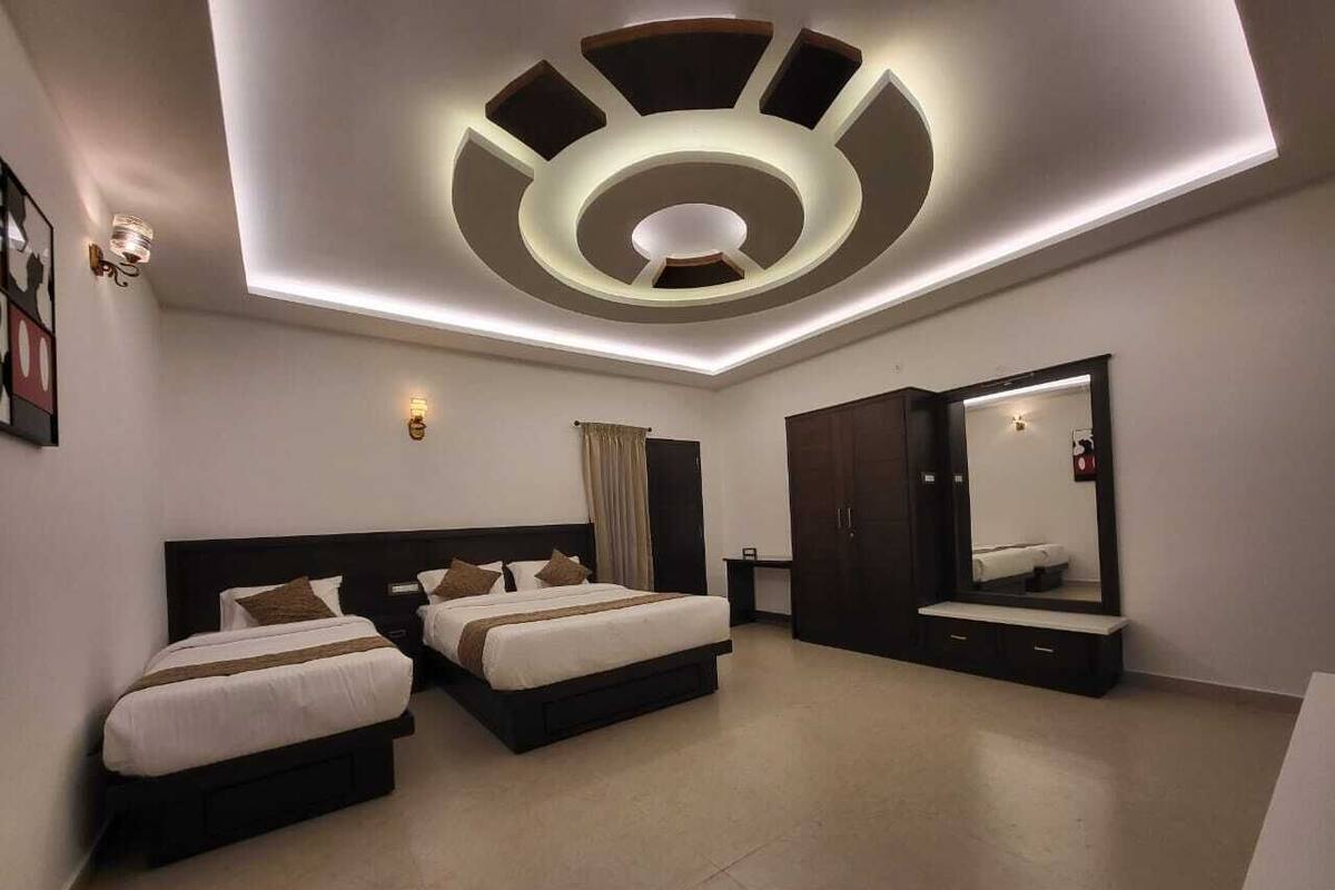 A modern hotel room with two beds, a large mirror, and a unique ceiling design.