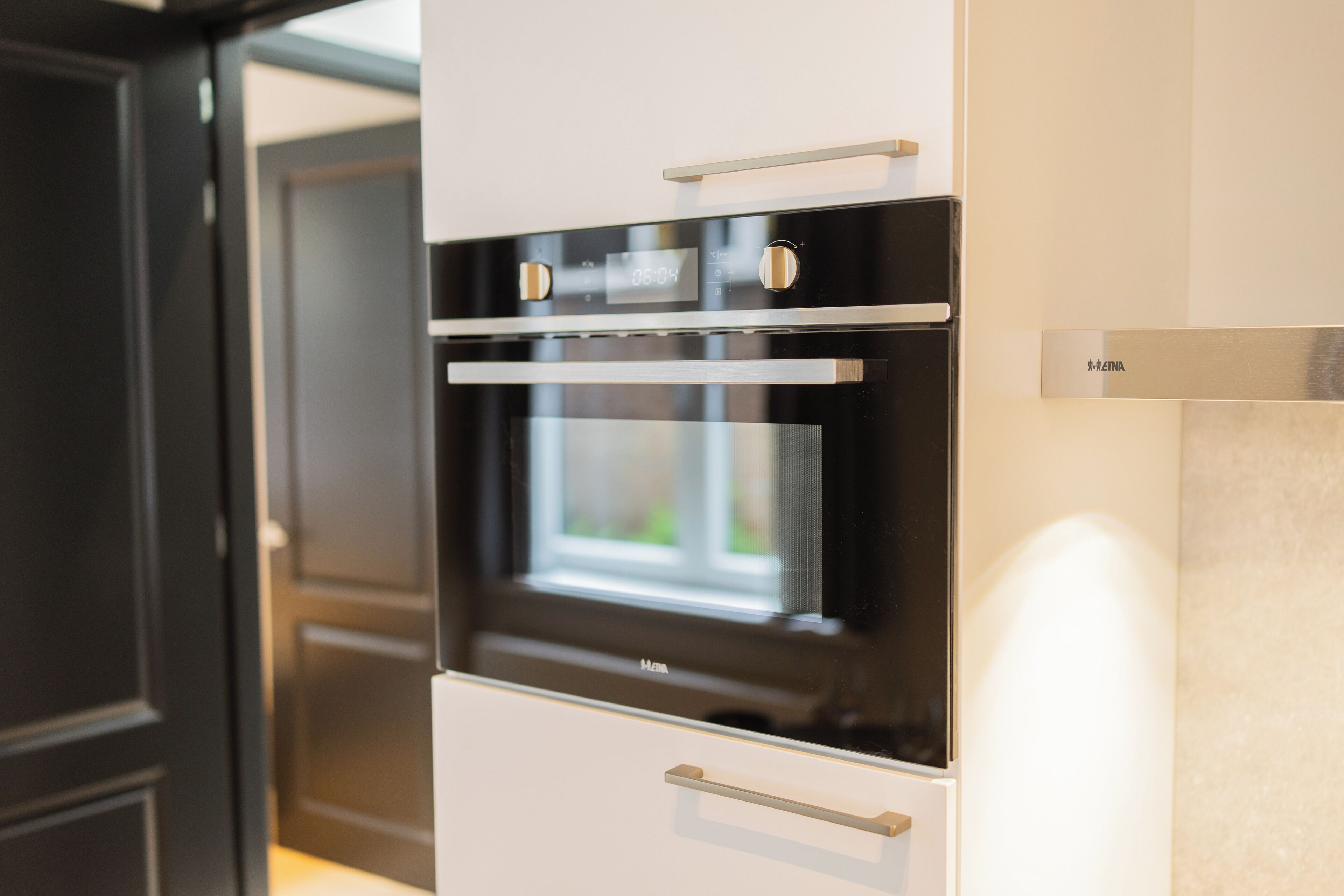 Una cocina moderna con horno empotrado y microondas.