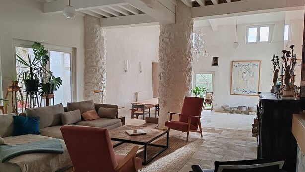 Un salon spacieux comprenant un canapé, des fauteuils, une table basse et une cheminée.