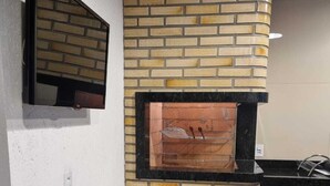 Eine Küche mit integriertem Backsteinofen, einer schwarzen Arbeitsplatte und einem Regal mit Küchenutensilien.