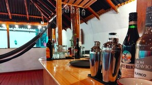 Eine Bar mit einem Holzboden, verschiedenen Flaschen und Gläsern.